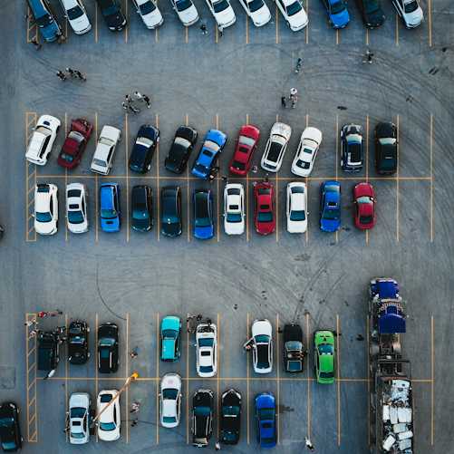 Illustrative overhead photograph of parked cars representing competition in the European vehicle market; not the October EU-China negotiations, Volkswagen event, or a specific hybrid model.