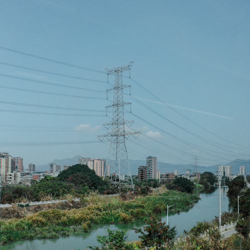 Electricity pylons above a city and river, illustrating power infrastructure; not a Ukrainian strike site or a photograph of the October 7 attacks.