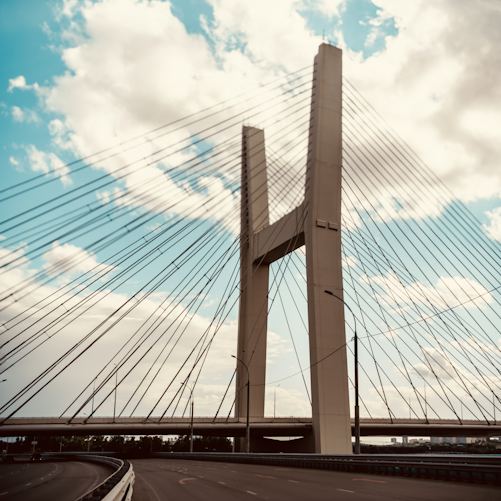 Illustrative photograph of a cable-stayed road bridge under a cloudy sky; this is not the New Yalu River Bridge between China and North Korea.